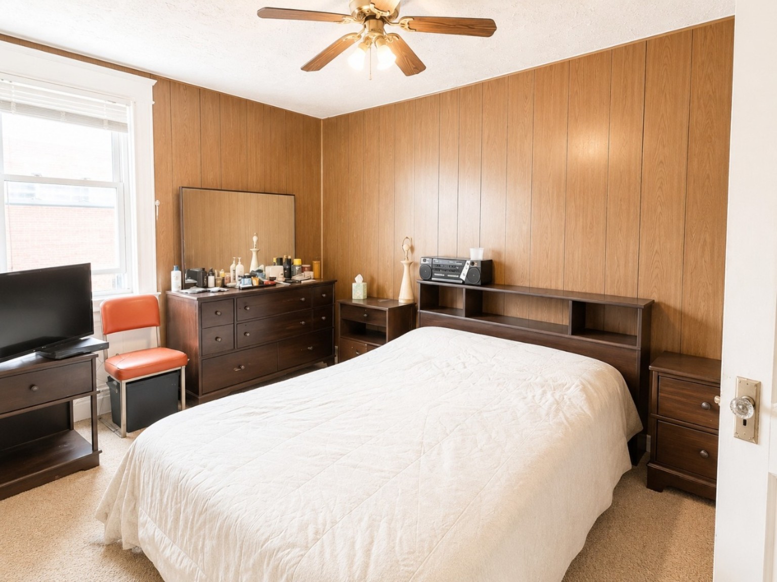 Bedroom with warm wood-paneled accent wall